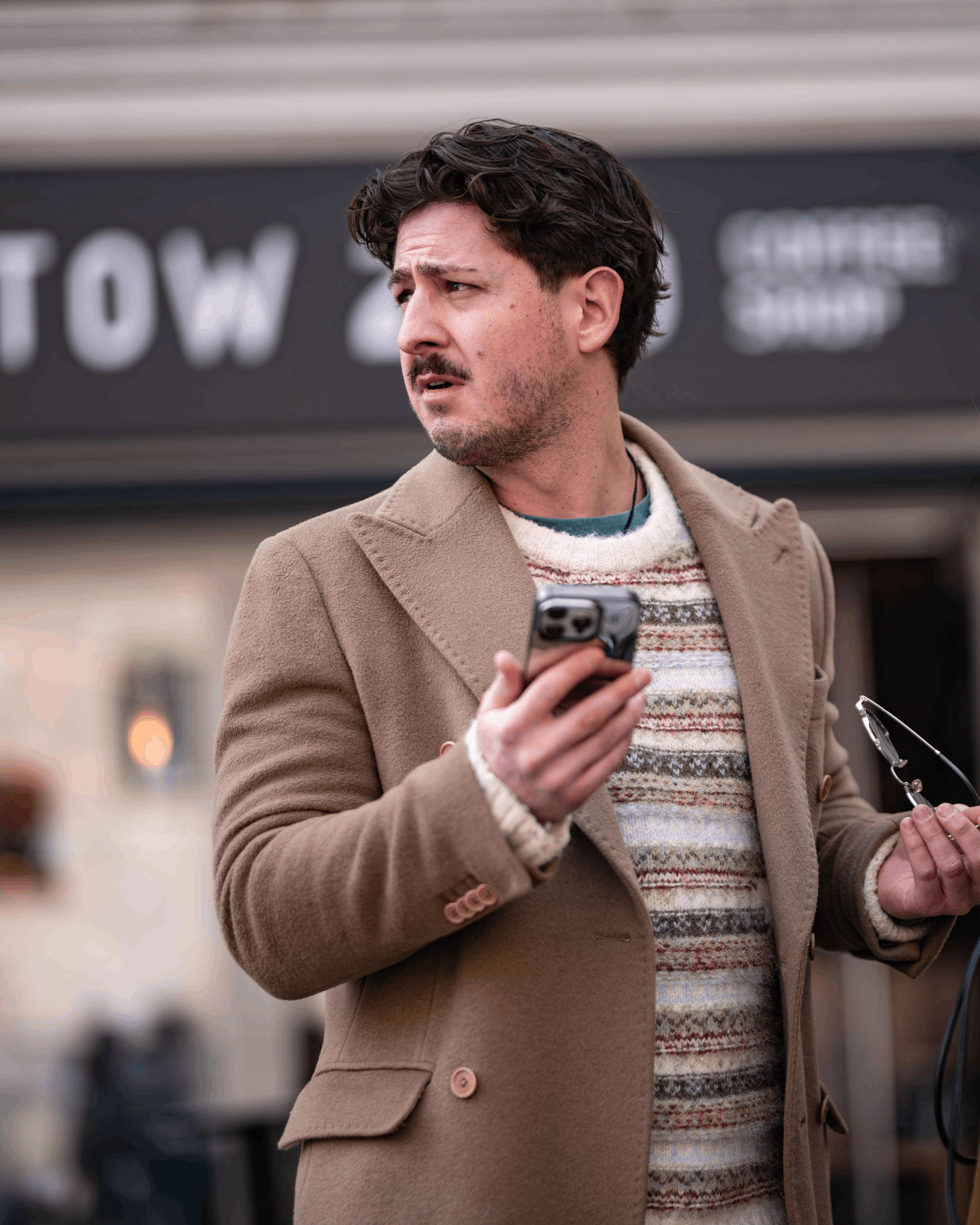 Vito on the street in a camel coat